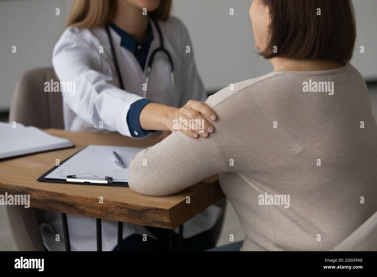 Close up young female doctor supporting older patient. Stock Photo