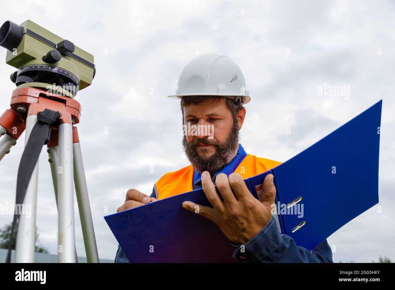 A Civil Engineer Writes Down The Readings Of The Optical Level On A Piece Of Paper In A Folder A Man Checks The Level For Building A House Stock Photo Alamy