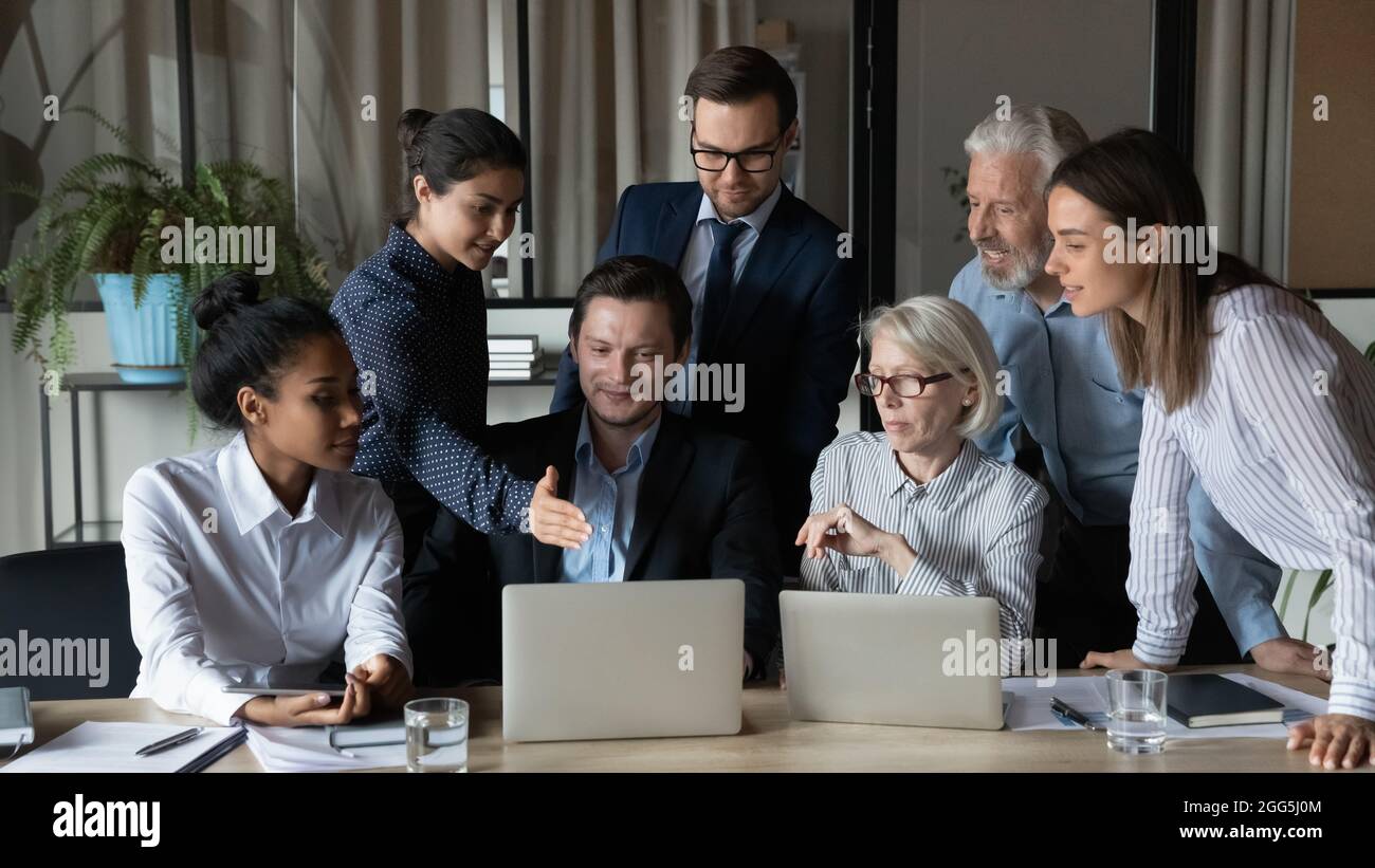 Diverse employees team working on online project, using laptops together Stock Photo