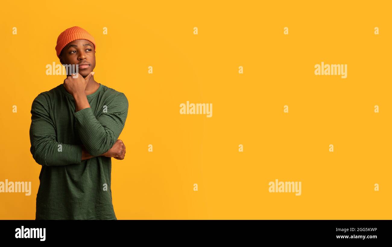 Interesting Offer. Pensive Young Hipster Guy Touching Chin And Looking Aside Stock Photo