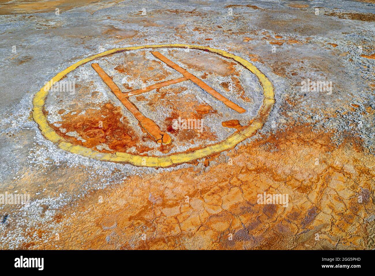 Rusty helipad sign over contaminated ground of abandoned mining area, dystopian background Stock Photo