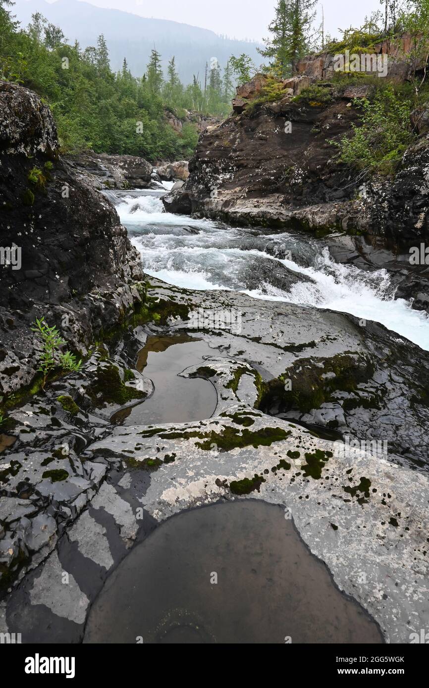 Putorana Plateau, a waterfall on the Grayling Stream. Mountain stream on a  cloudy day Stock Photo - Alamy