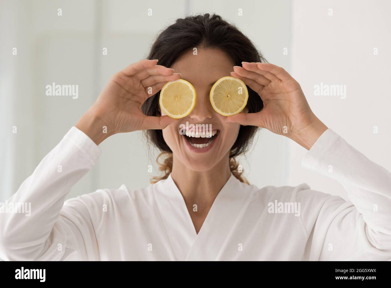 Happy young smiling woman holding lemon slices. Stock Photo