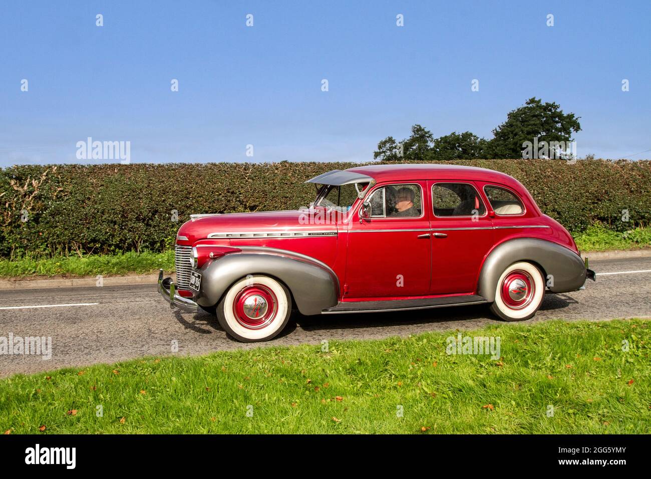 1940 40s forties red CHEVROLET Chevy Special DeLuxe  3800cc petrol 4dr saloon en-route to Capesthorne Hall classic August car show, Cheshire, UK Stock Photo