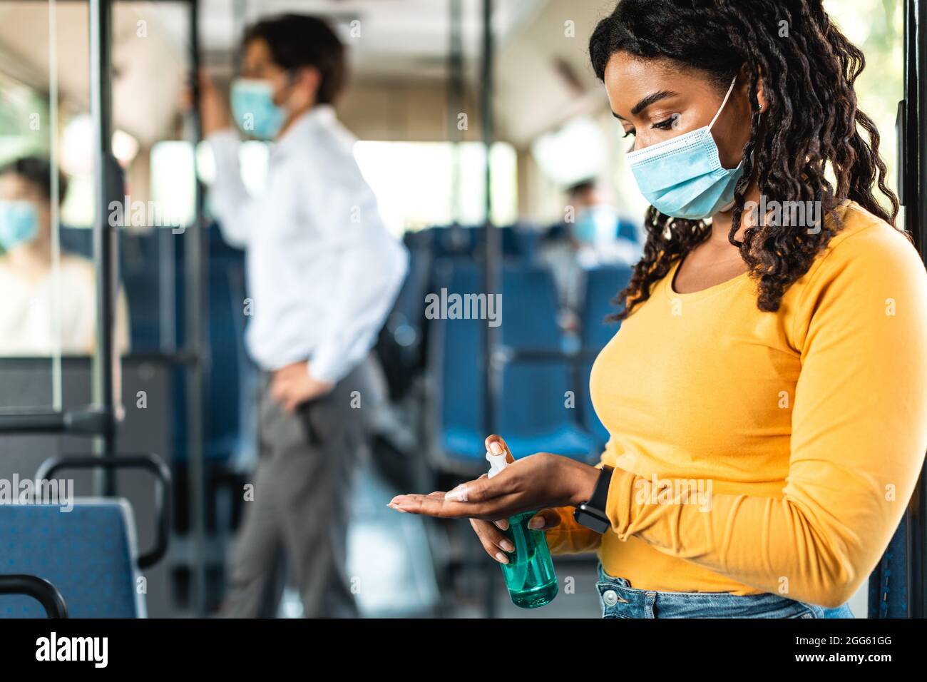 Black woman going by bus, using sanitizer on hands Stock Photo - Alamy