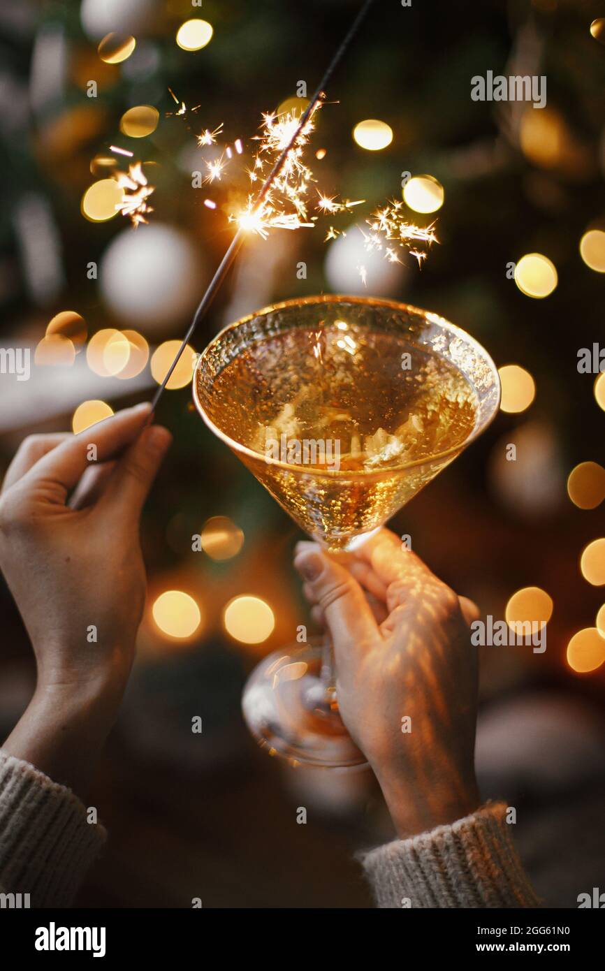 duurzame grondstof map mobiel Happy New Year! Woman celebrating with firework light and champagne glass  on background of christmas tree and glowing star. Hands holding burning spar  Stock Photo - Alamy