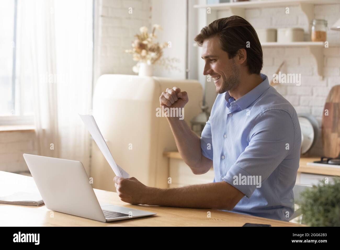Joyful young man celebrating success reading news in letter. Stock Photo