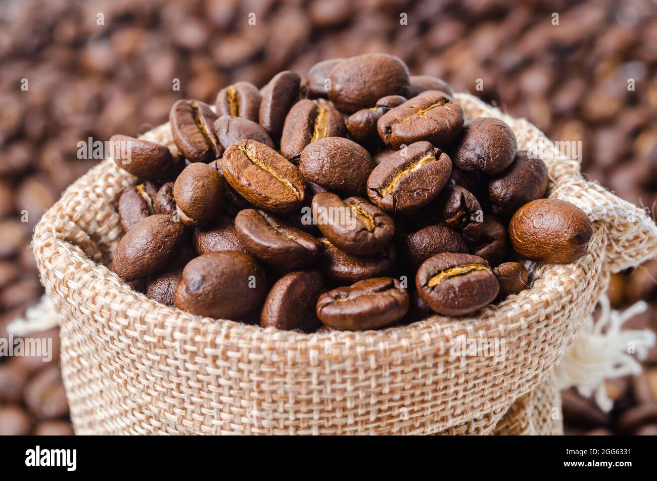 Coffee beans in sack bag on coffee beans background Stock Photo - Alamy