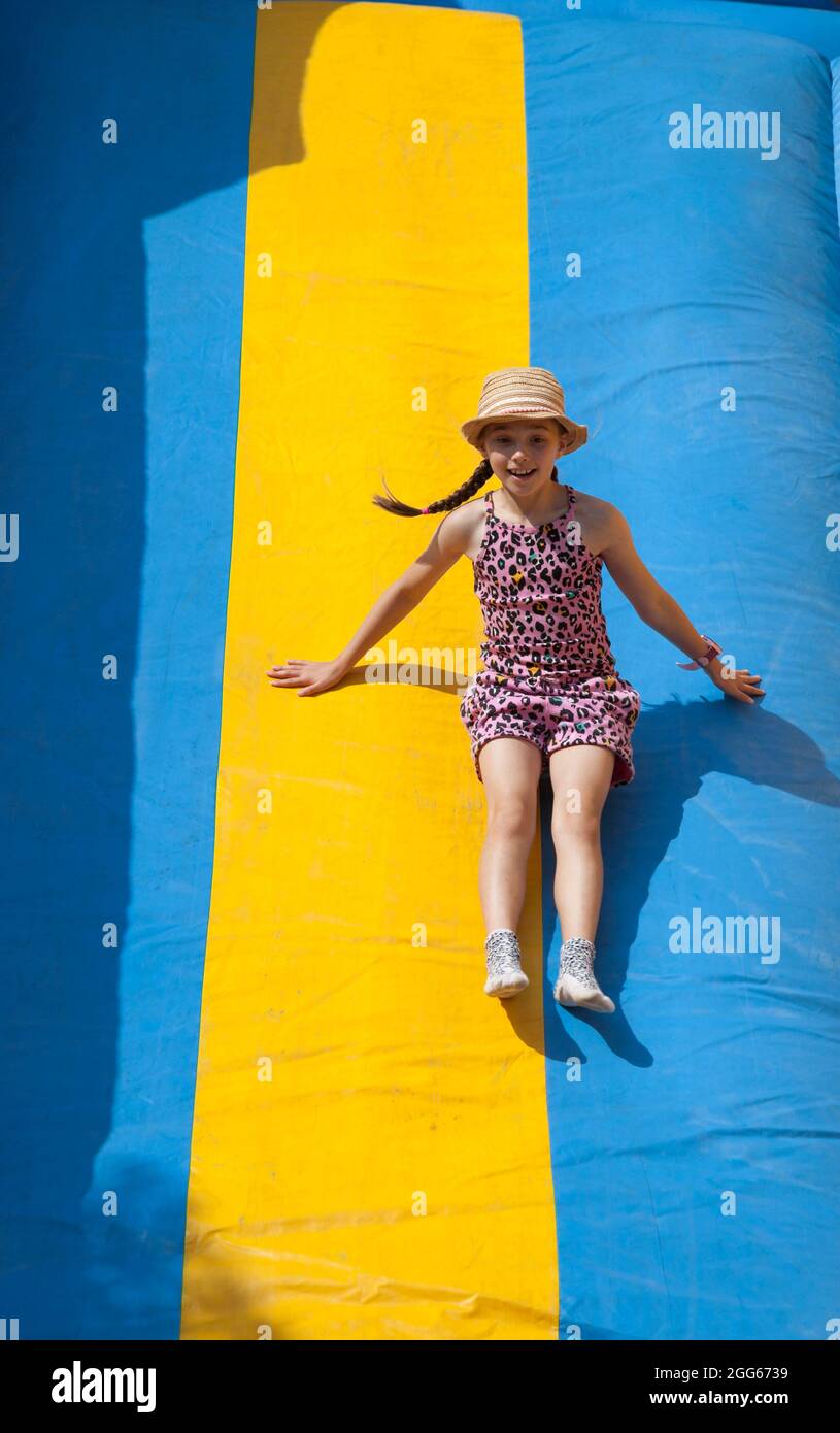 Girl on the slide at the Summer Fayre in Helensburgh, Scotland Stock Photo