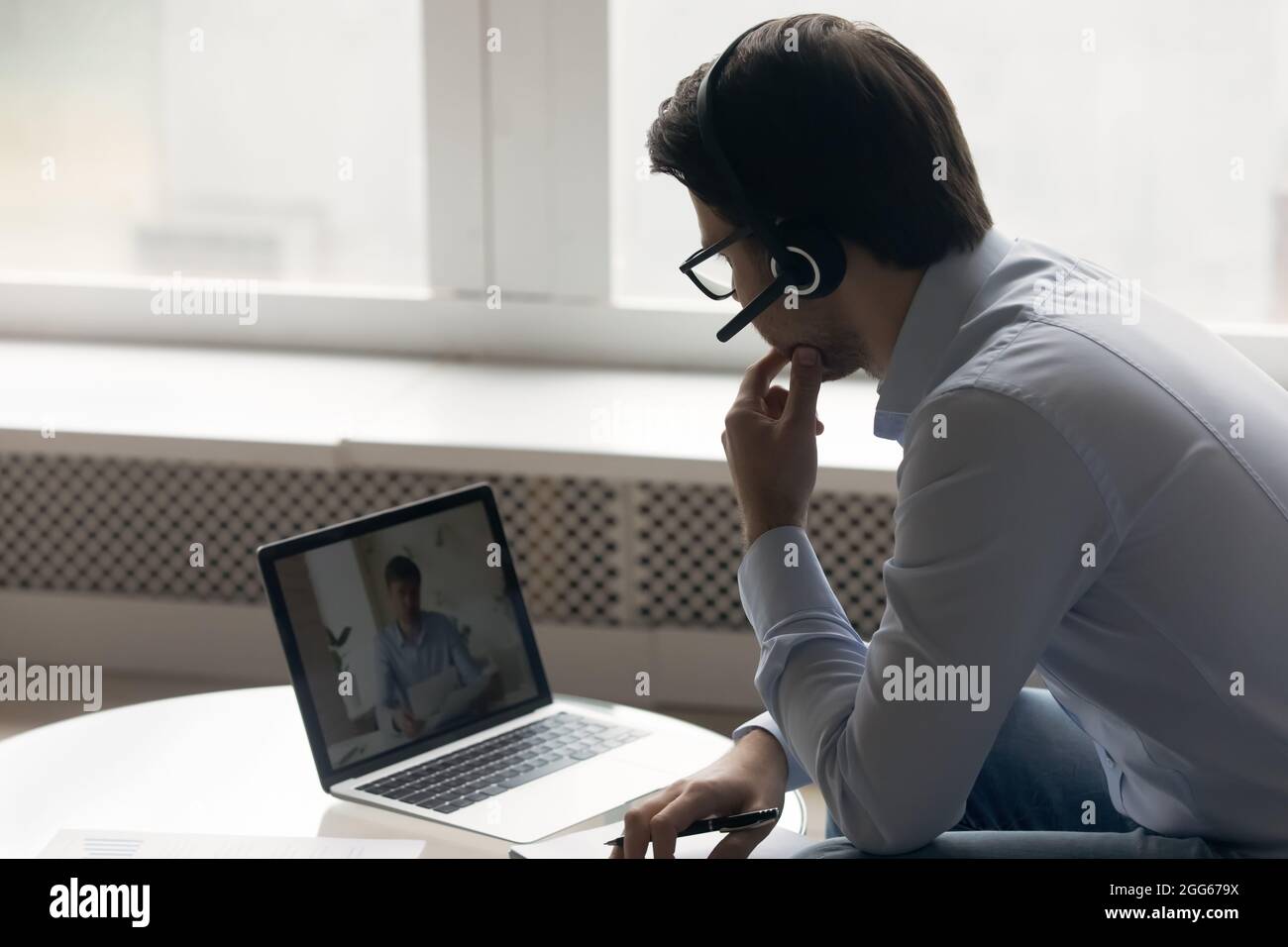 Business man in wireless headset using laptop Stock Photo