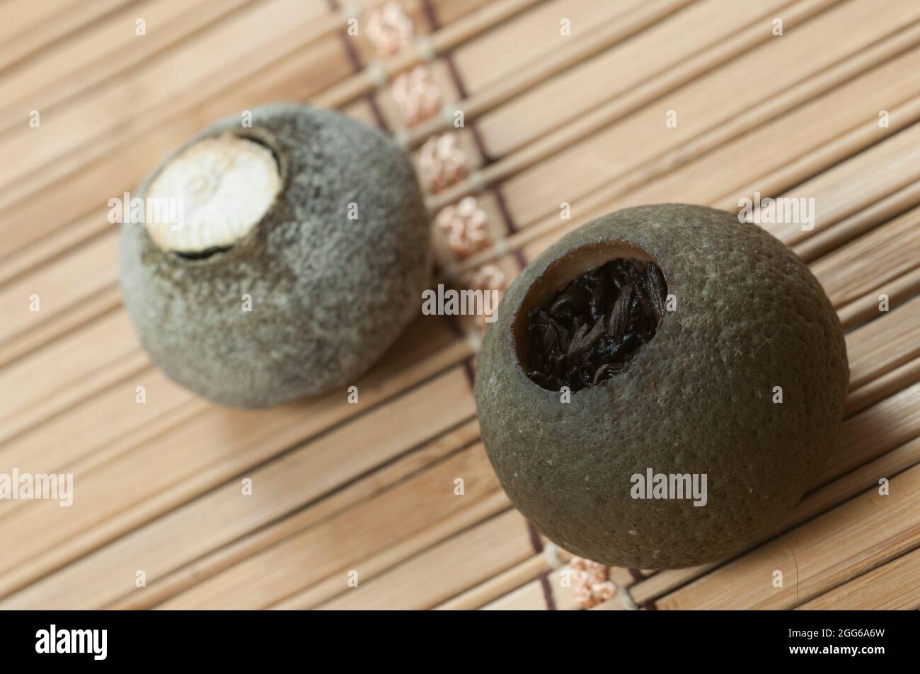 Pu'er tea in tangerine on a bamboo background, close up Stock Photo