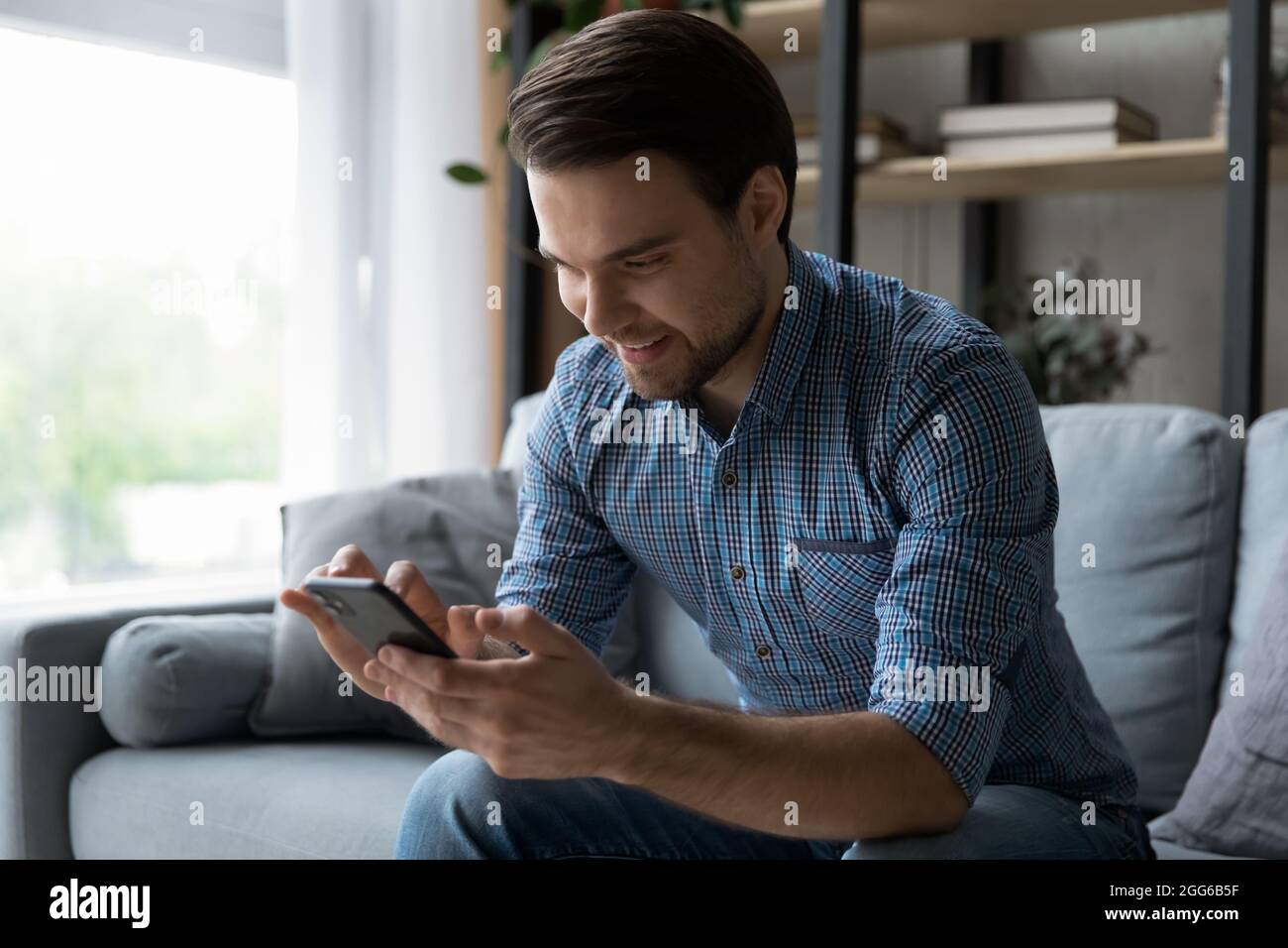 Happy mobile phone user reading text message with good news Stock Photo