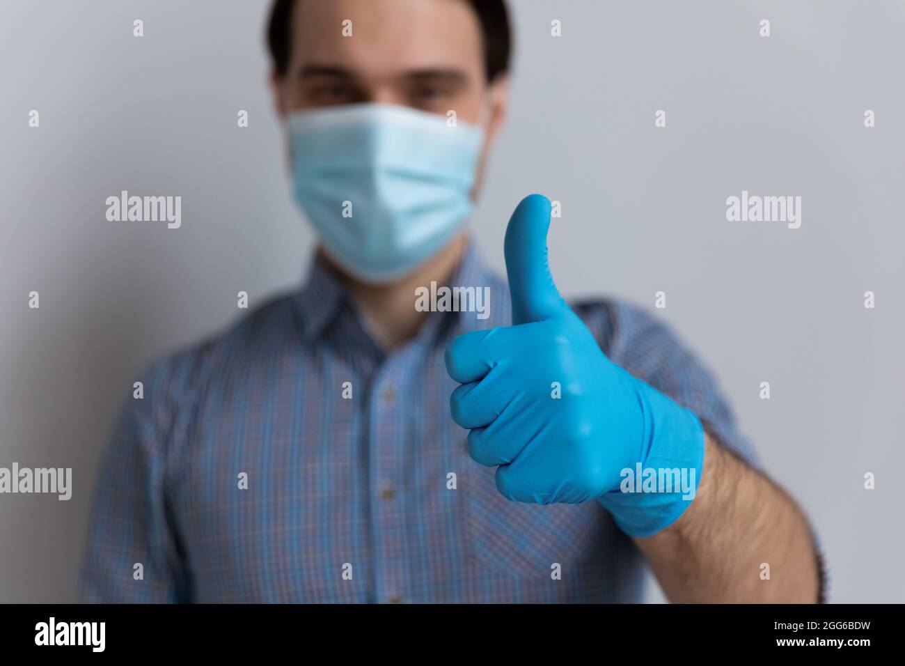 Positive millennial guy in medical face mask and latex gloves Stock Photo