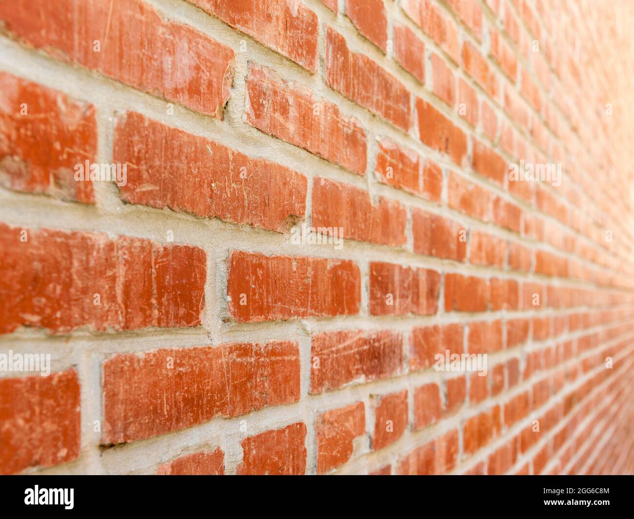 Close-up diminishing perspective of red brick wall from left to right. Stock Photo