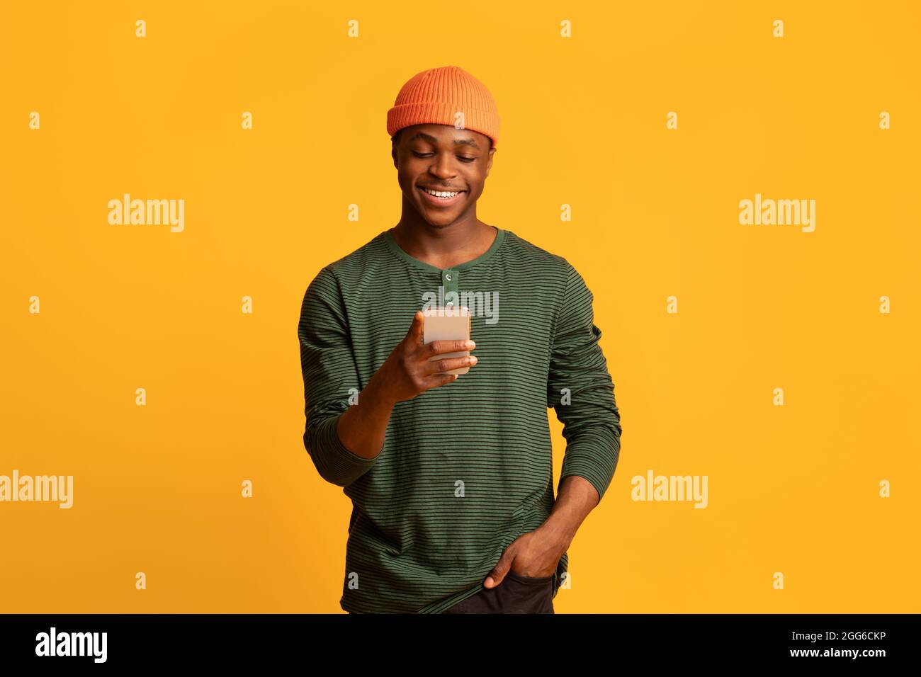 Cool App. Happy young black guy using smartphone, browsing new application Stock Photo