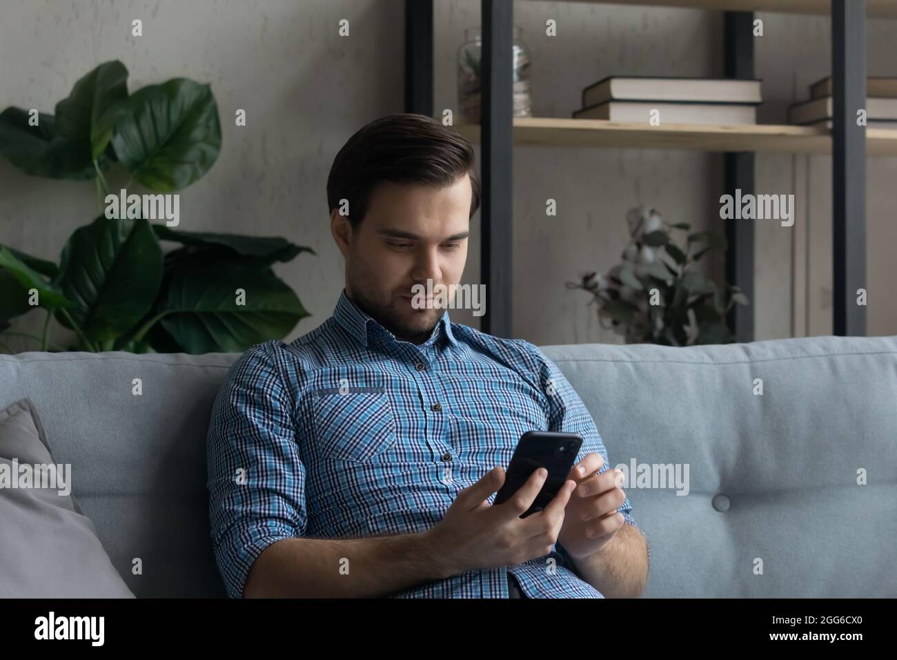 Serious mobile phone user reading text message on screen Stock Photo