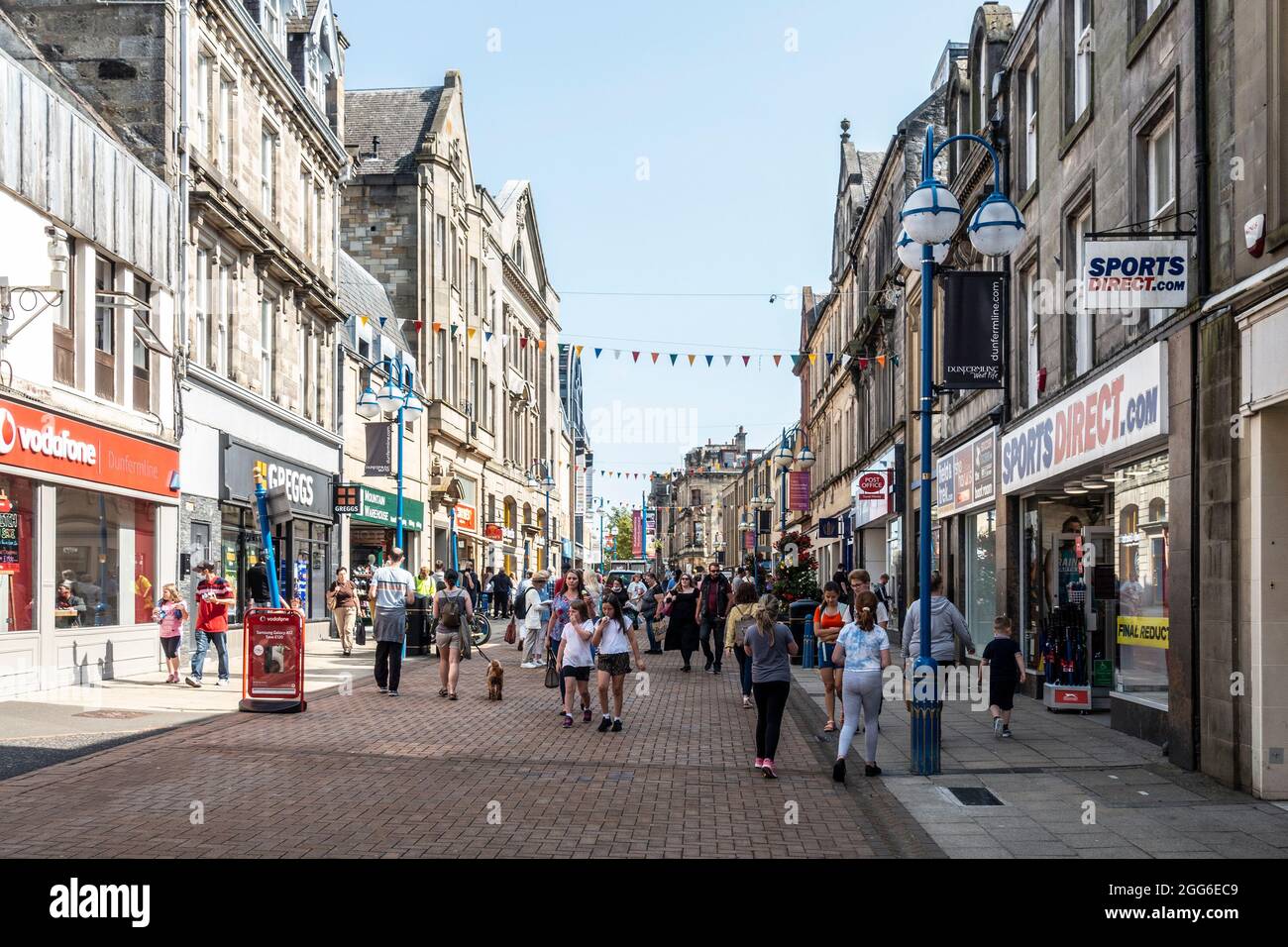 Shoppers on a Summer Saturday in the bustling pedestrianised High Street in Dunfermline, Fife, Scotland. Men, women and children outside shops. Stock Photo