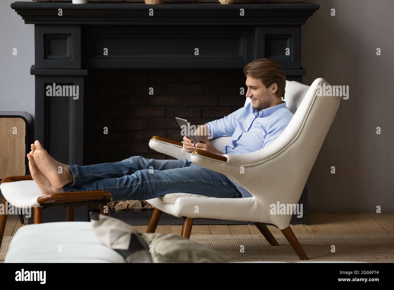Relaxed young man using digital computer tablet. Stock Photo
