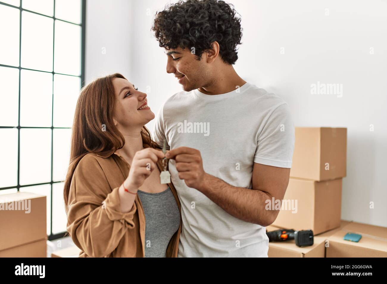 Young couple smiling happy holding key of new home Stock Photo - Alamy