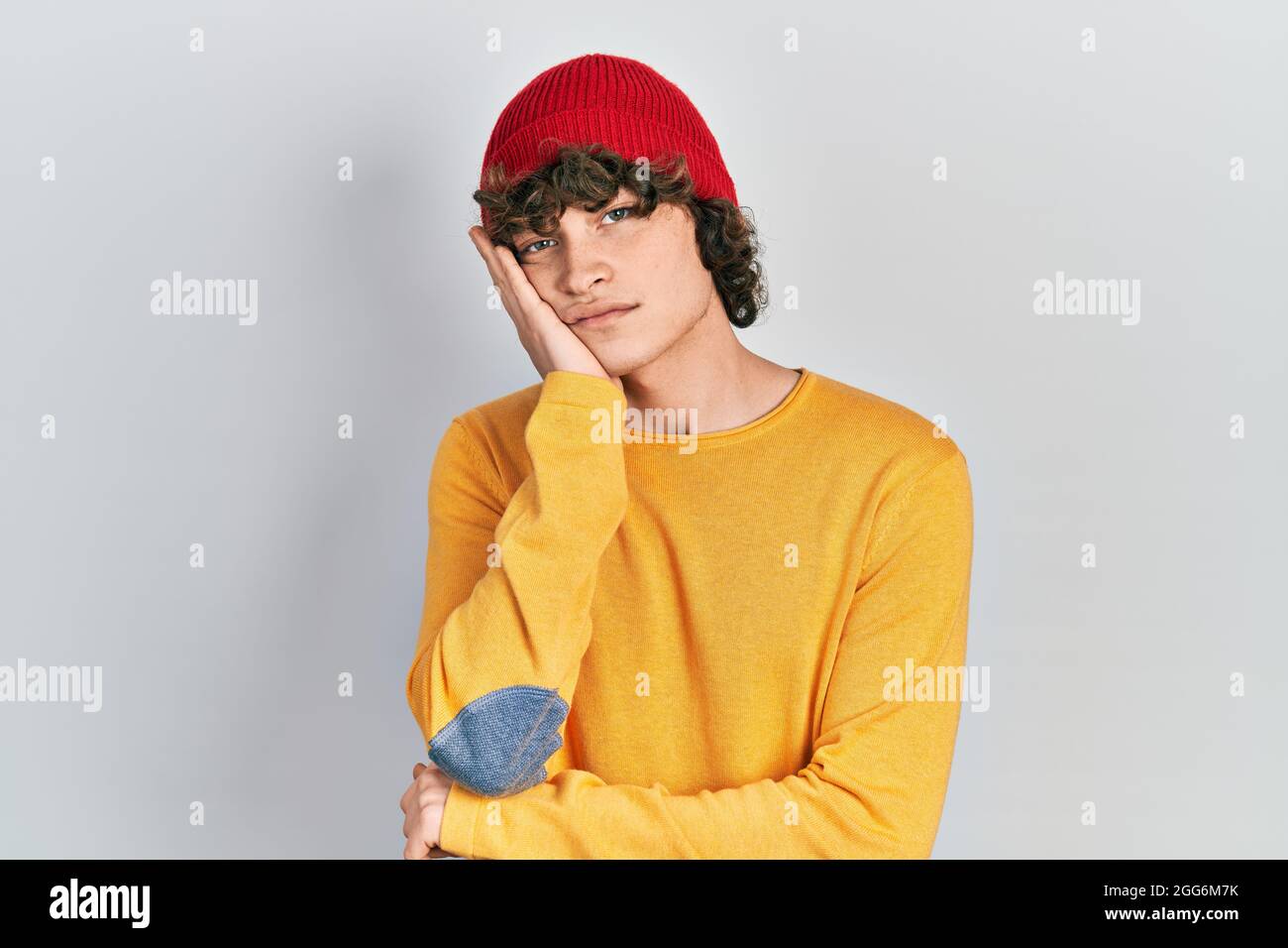 Handsome young man wearing wool hat thinking looking tired and bored ...