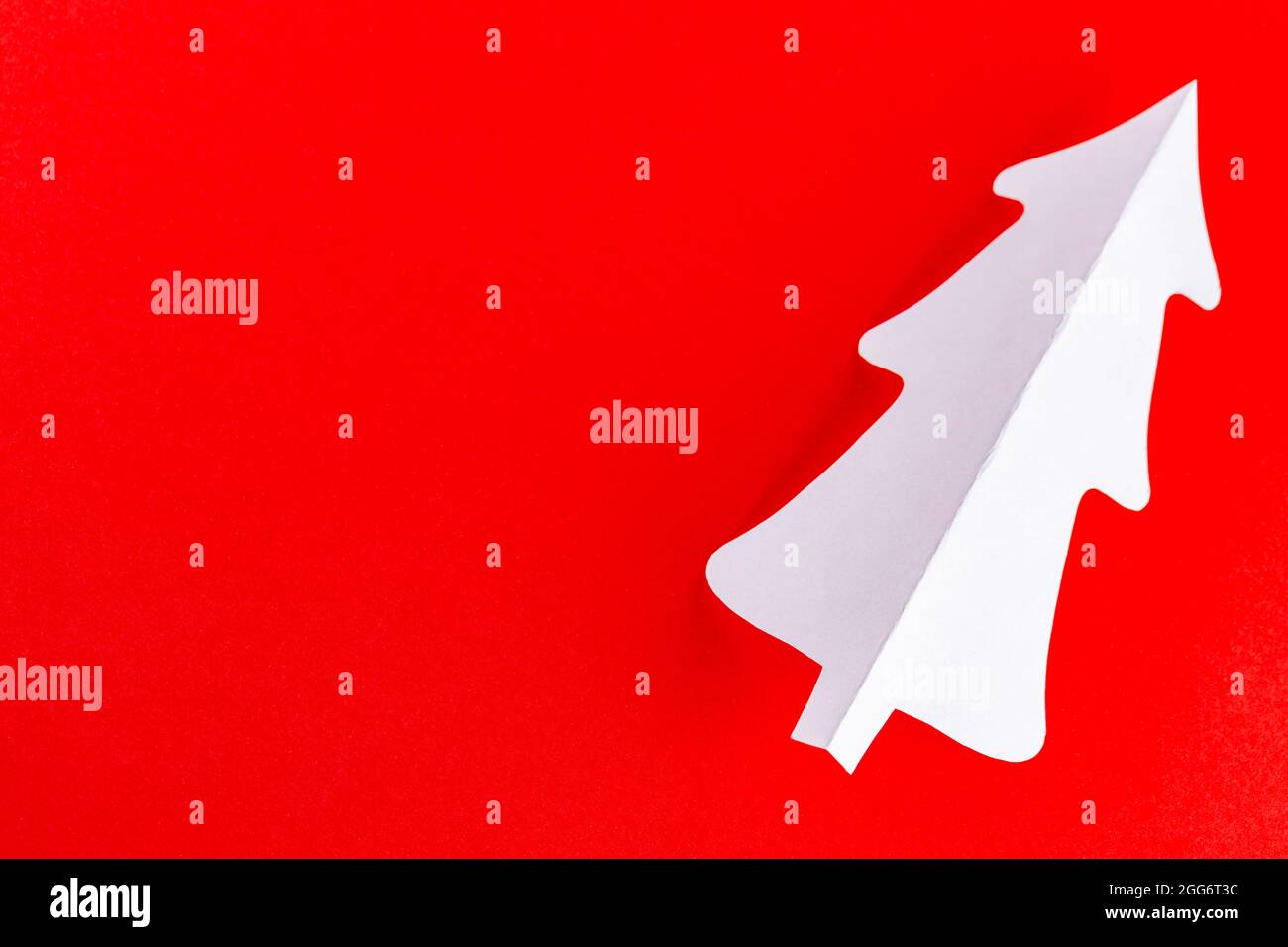 Paper Christmas tree on a red background. White paper christmas tree ...
