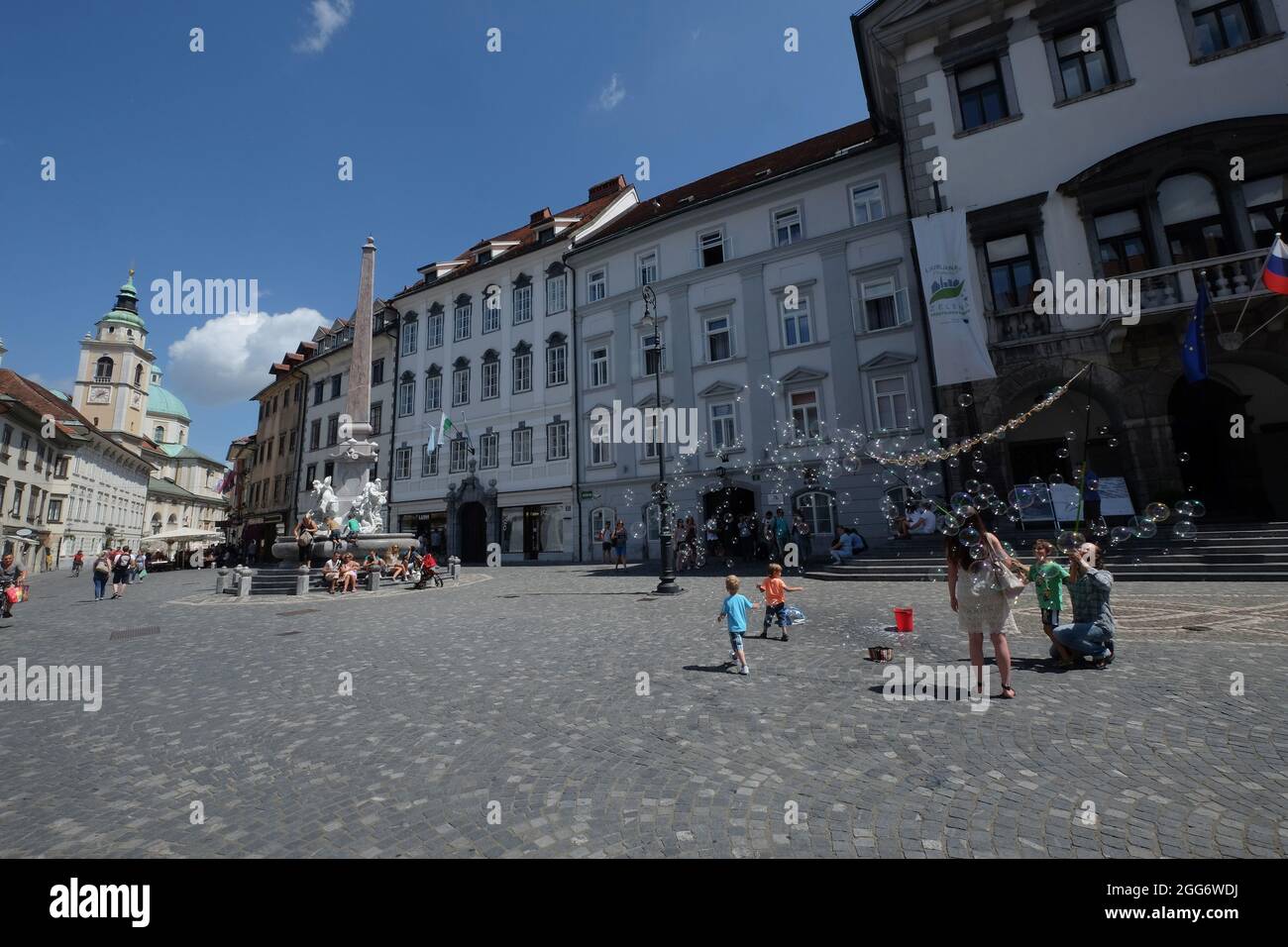 Children and their parents enjoy the soap bubble show of the street artist in Ljubljana, Slovenia Stock Photo