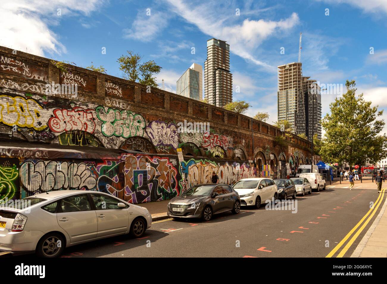 LONDON ARTISTIC AND CULTURAL AREA AROUND BRICK LANE WITH CREATIVE DESIGNS AND SLOGANS SCLATER STREET WALL AND NEARBY TOWER BLOCKS Stock Photo