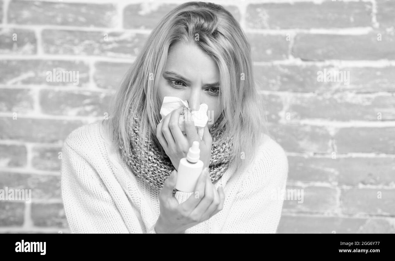 Blowing her nose. Pretty girl with runny nose holding nasal drops. Cute