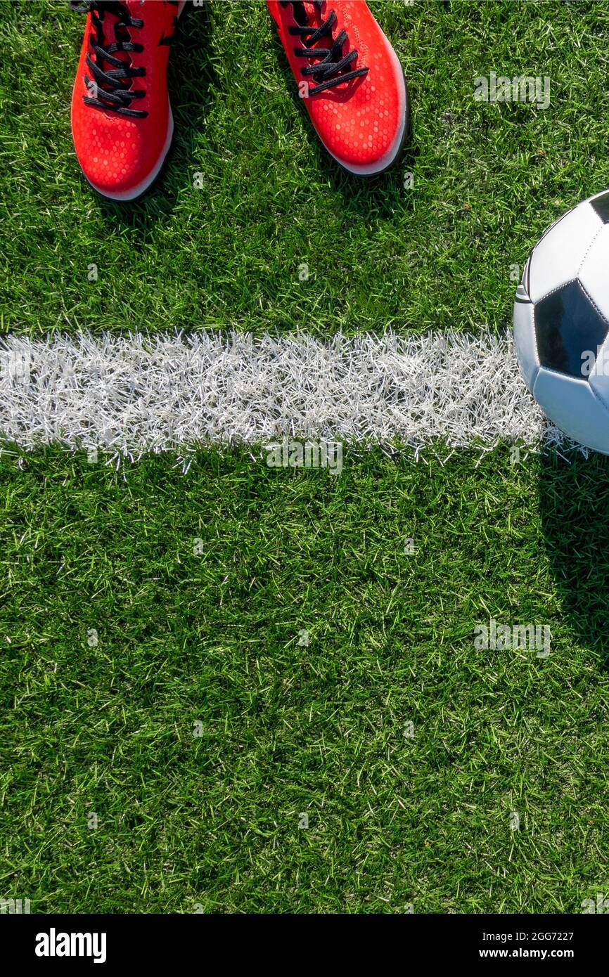 Soccer football background. Soccer ball and pair of football sports shoes  on artificial turf soccer field. Top view Stock Photo - Alamy