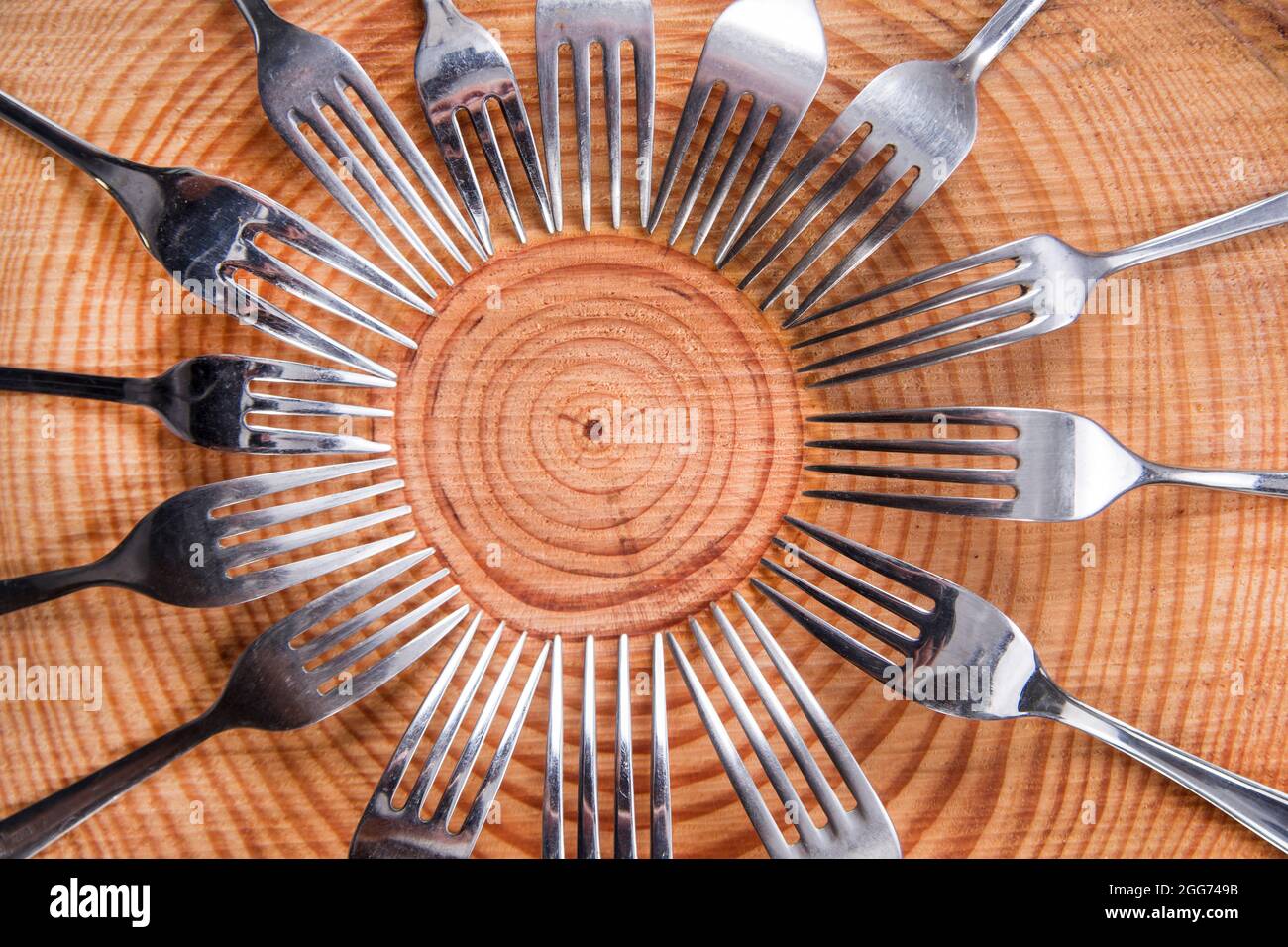 Series of different forks in a circle of pine board Stock Photo