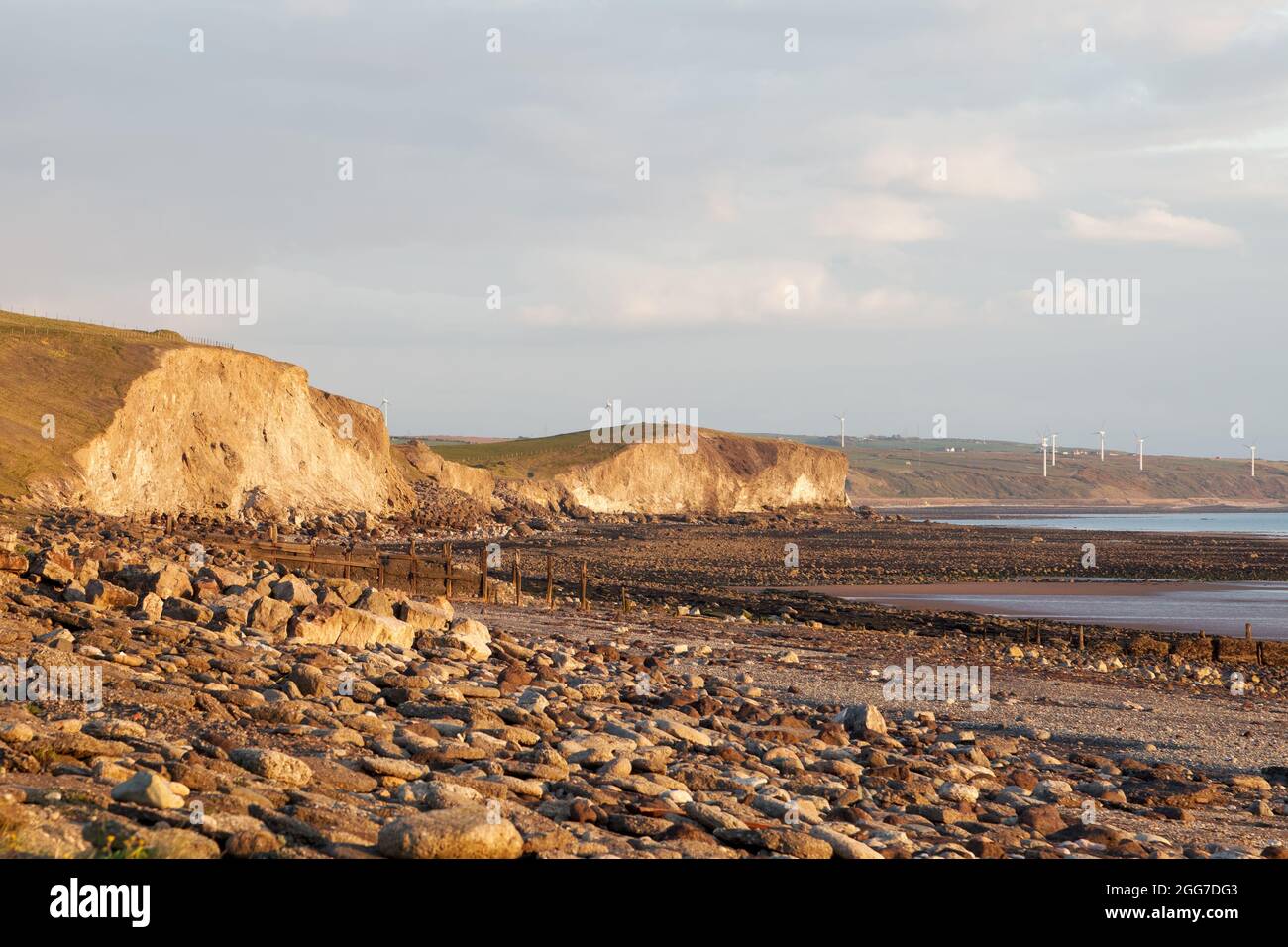 Cliffs and a windfarm to the south of the Port of Workington on the west Cumbrian coastline Stock Photo