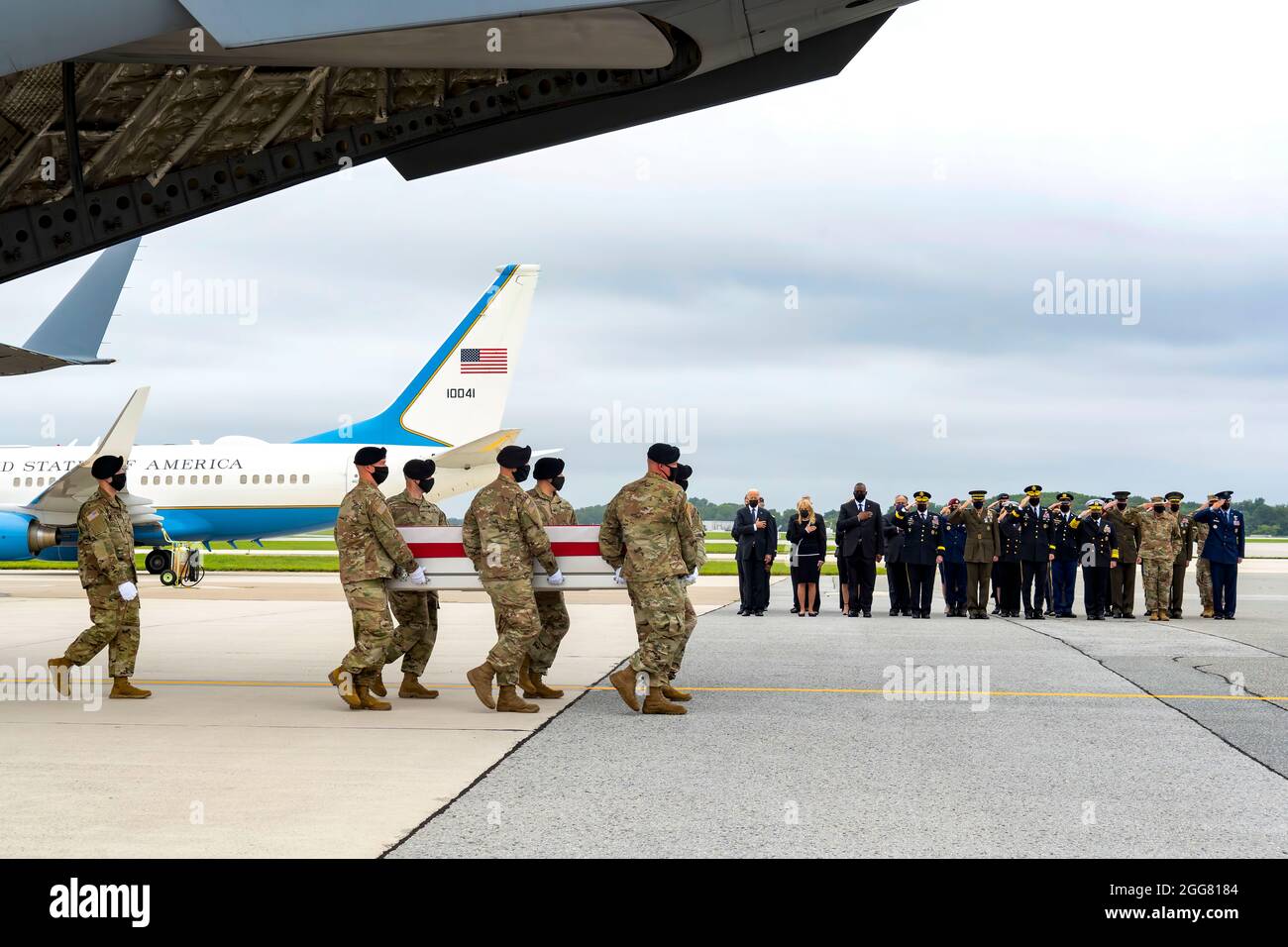 A U.S. Army carry team transfers the remains of Army Staff Sgt. Ryan C. Knauss of Corryton, Tennessee, Aug. 29, 2021 at Dover Air Force Base, Delaware. Knauss was assigned to the 9th Psychological Operations Battalion, 8th Psychological Operations Group, Ft. Bragg, North Carolina. President and Mrs. Biden along with Secretary of Defense Austin stand with hands over their hearts.(U.S. Air Force photo by Jason Minto) Stock Photo