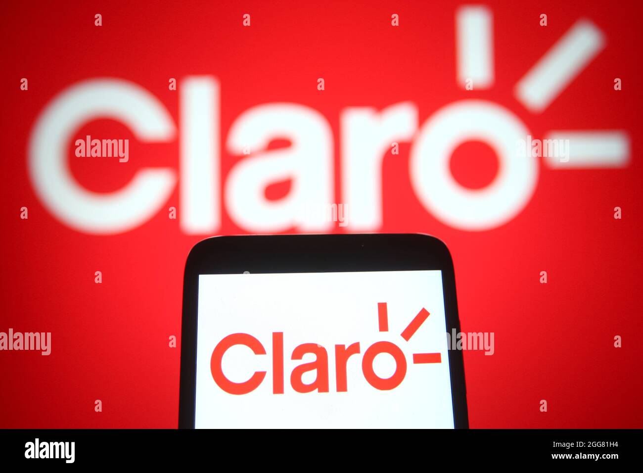 In this photo illustration, Claro logo is seen on a smartphone and a pc  screen Stock Photo - Alamy