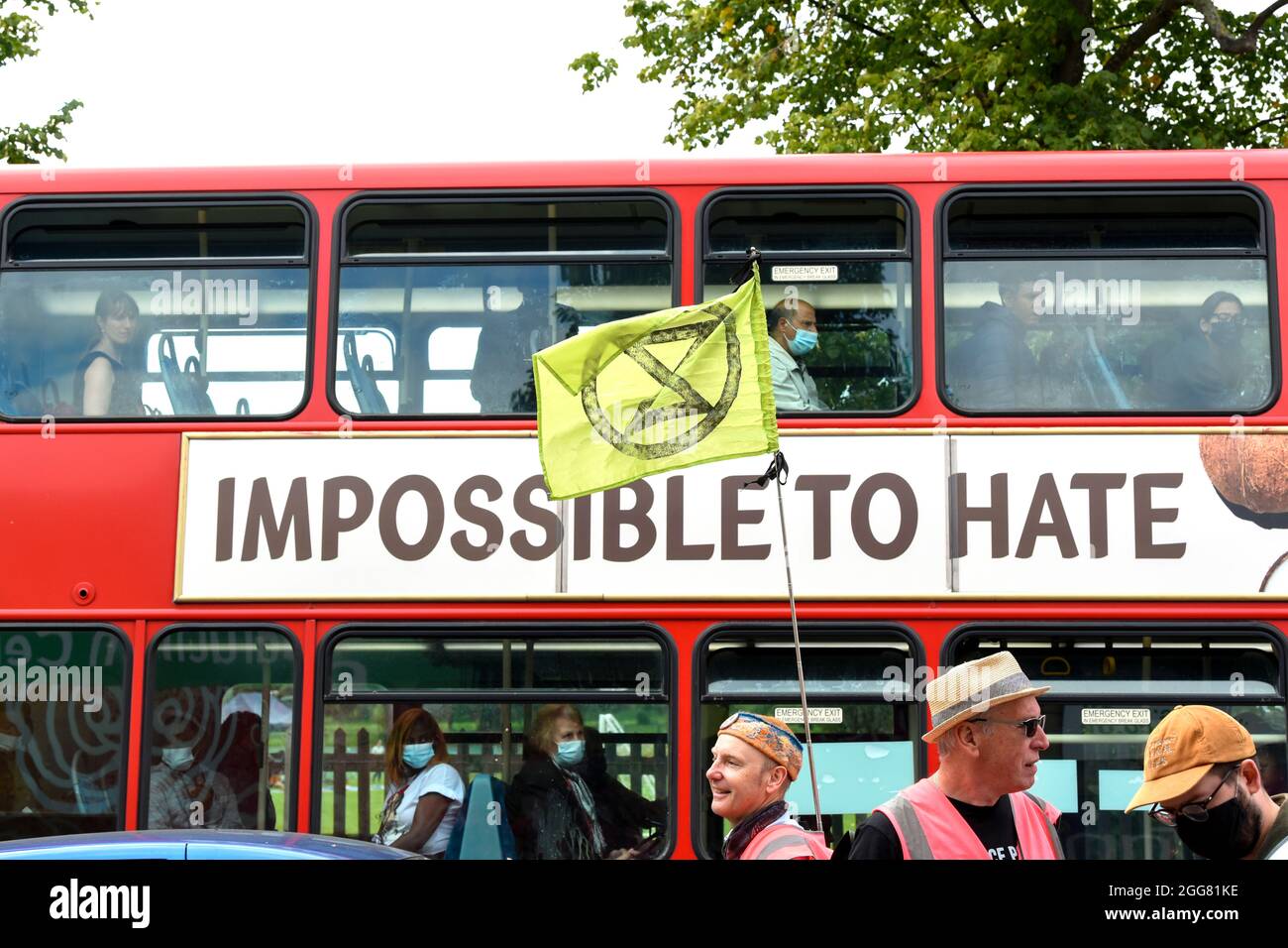 Extinction Rebellion protesters march past a bus with an advert saying  'Impossible to hate' during the protest.XR Unify is a BIPOC-led (black,  Indigenous and people of colour) group who are taking action