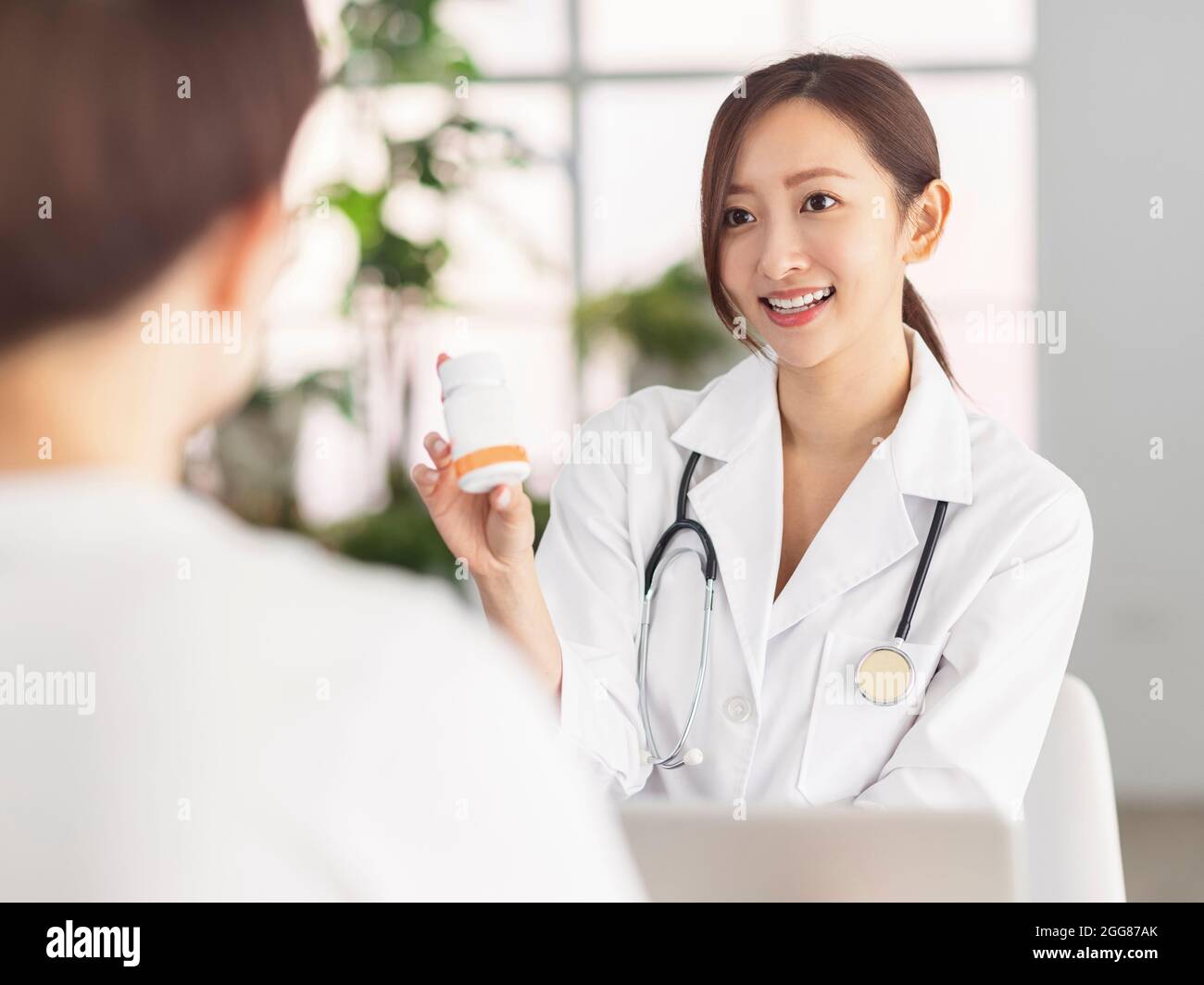 Smiling doctor showing pills to patient . Stock Photo