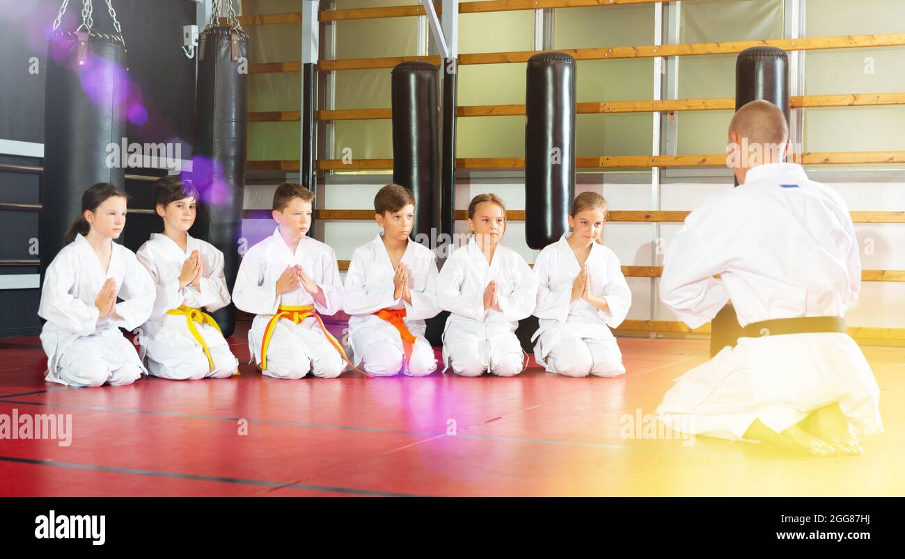 Children with their male instructor posing in karate class Stock Photo