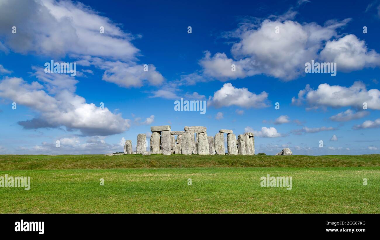 world famous stonhenge prehistoric stone circle monument on blue skygreen grass sunny background Stock Photo