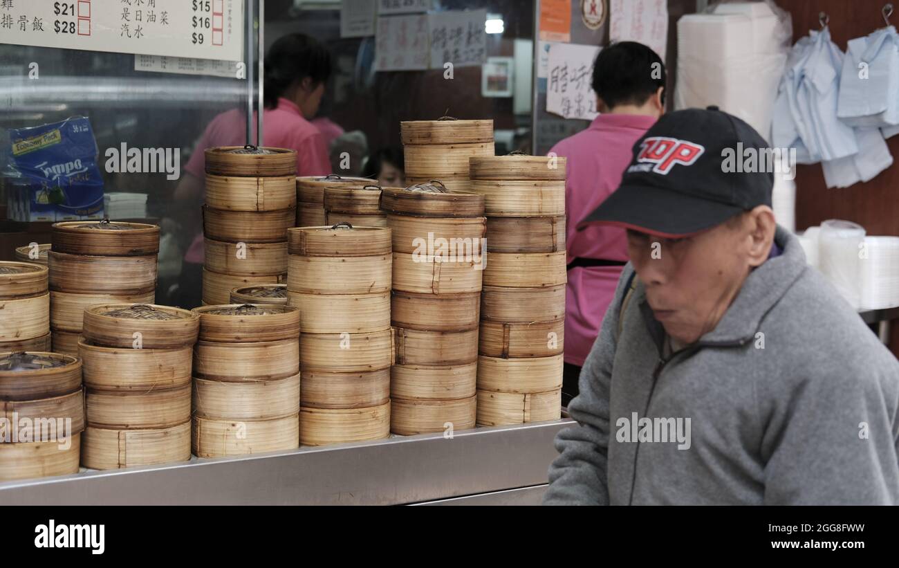 Man Wearing Sports Cap Walking Past Dim Sum  Cantonese cuisine Least affluent neighborhood Sham Shui Po Market Kowloon Hong Kong Stock Photo