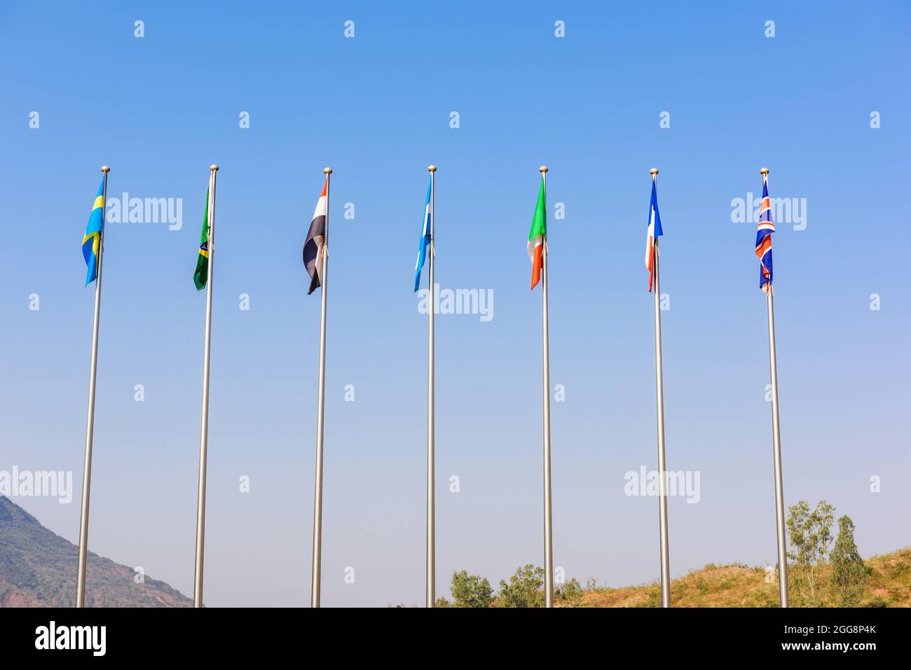 Various country flag poles with blue sky outdoors. Stock Photo