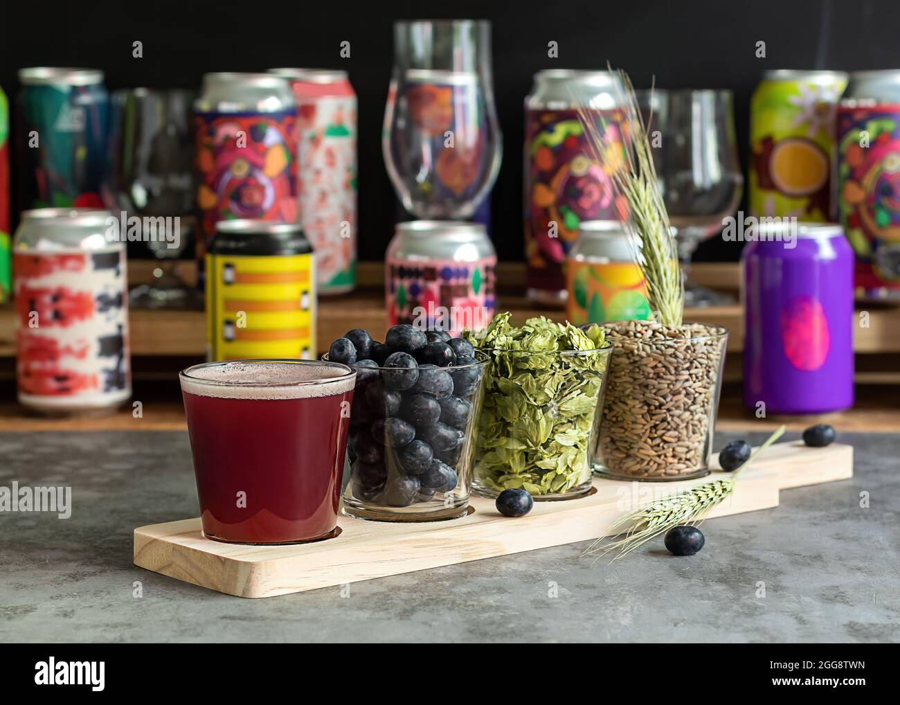 Sour fruited blueberry IPA with ingredients. Wooden board for flight set craft beer tasting Stock Photo