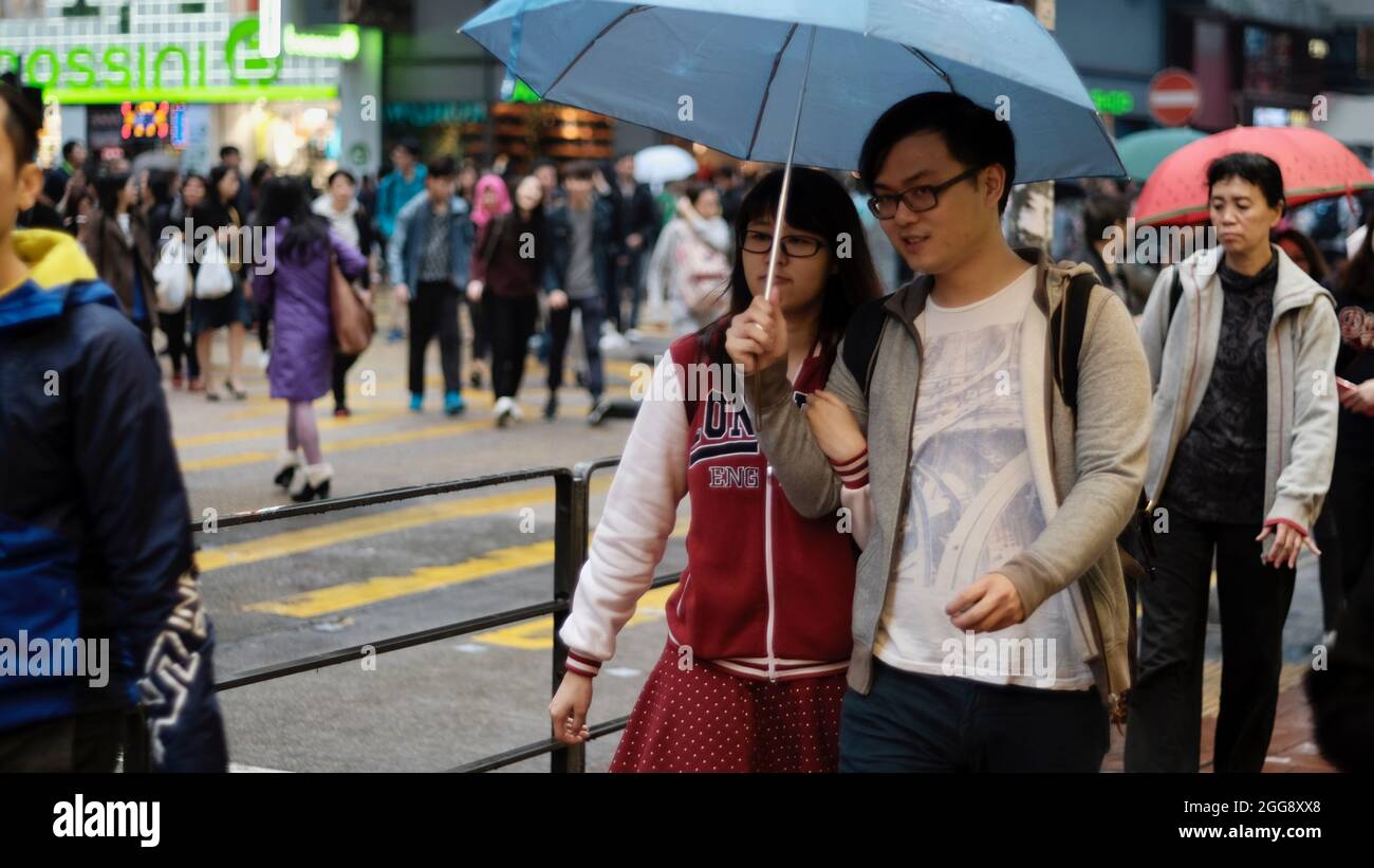 Boy and Girl Pedestrians Under Umbrella on Sai Yeung Choi St Mongkok Kowloon Hong Kong Stock Photo