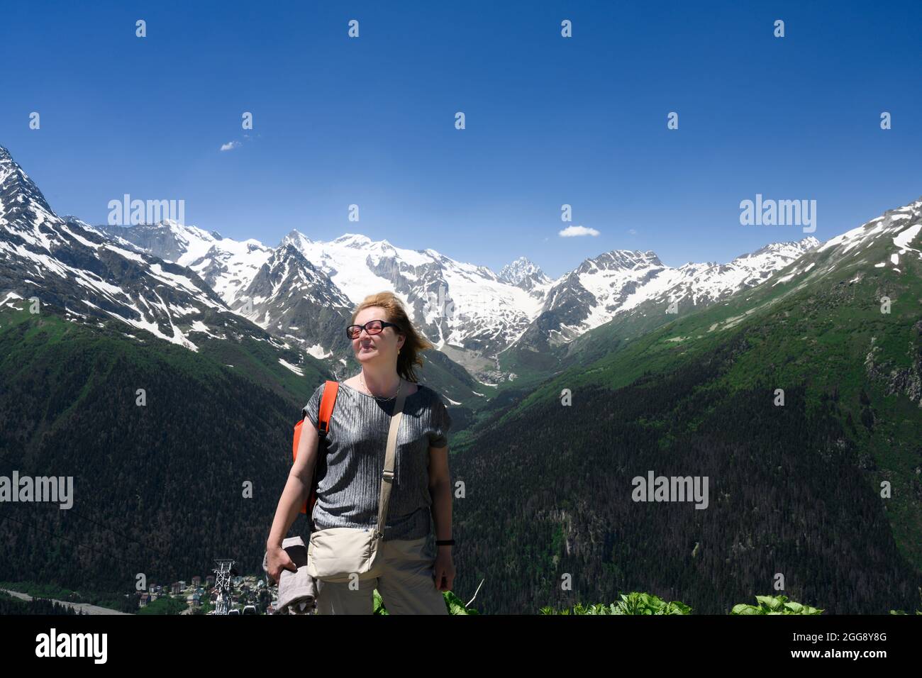 A female tourist enjoys the wind high in the mountains in the Caucasus Stock Photo