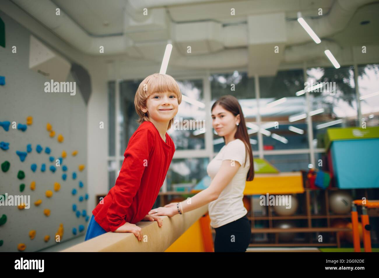Kids doing balance beam gymnastics exercises in gym at kindergarten or elementary school. Children sport and fitness concept Stock Photo