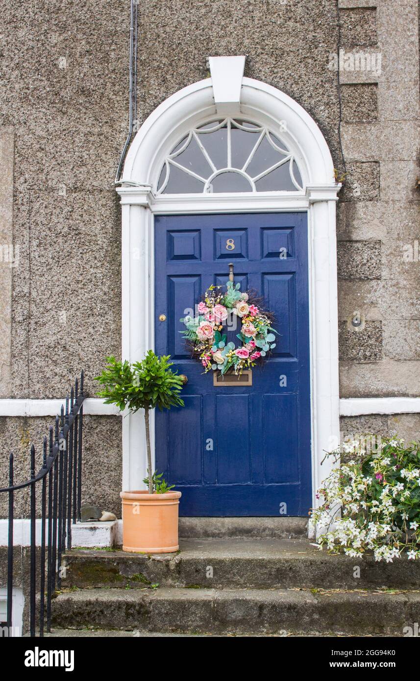 26 August 2021 A Geoargian styled panelled door and fanlight with a Colonial style concrete surround at the entrance to private accomodation on the ma Stock Photo