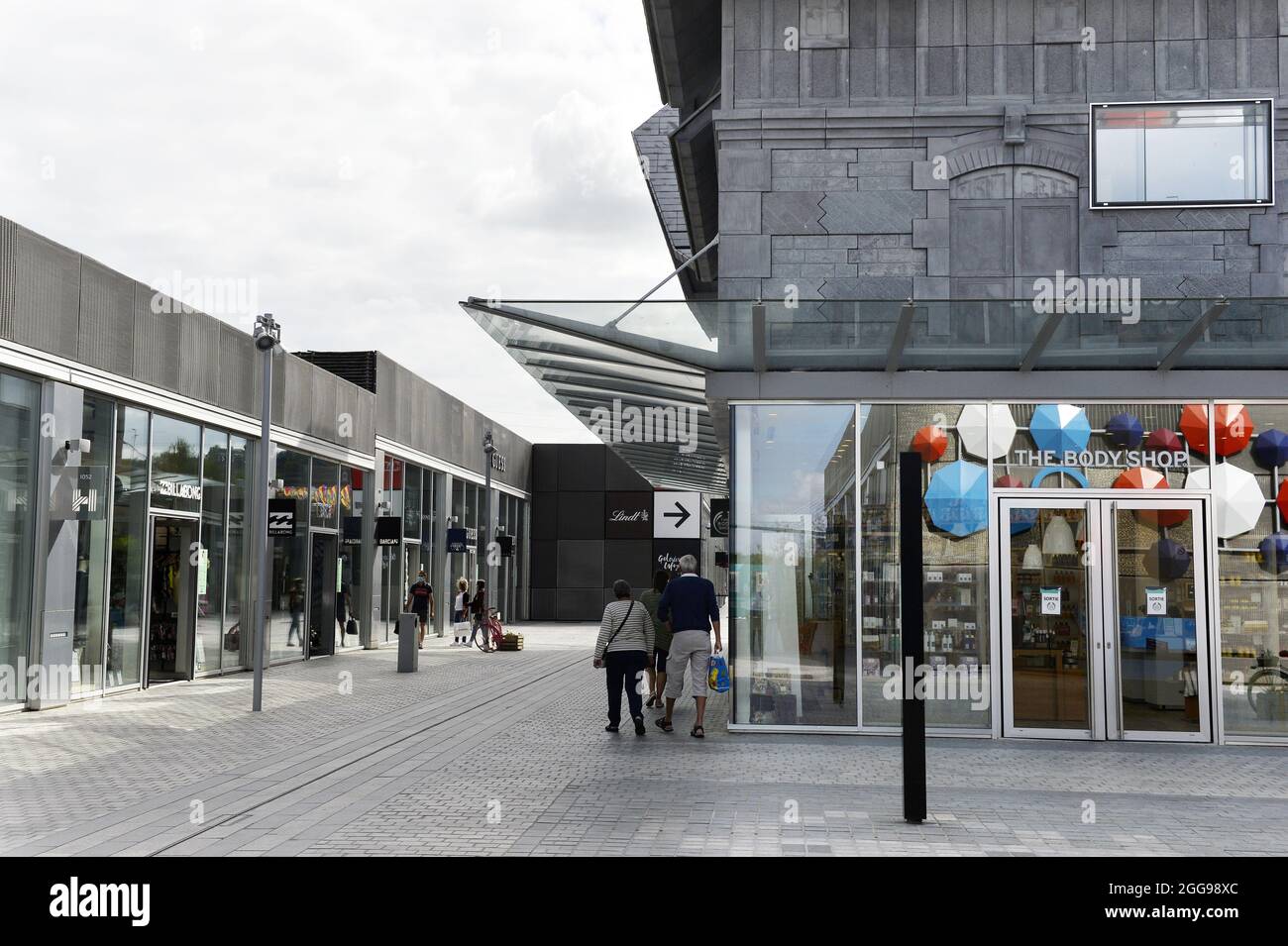Honfleur Normandy Outlet vue du centre commercial avec magasins et personnes Le Village des