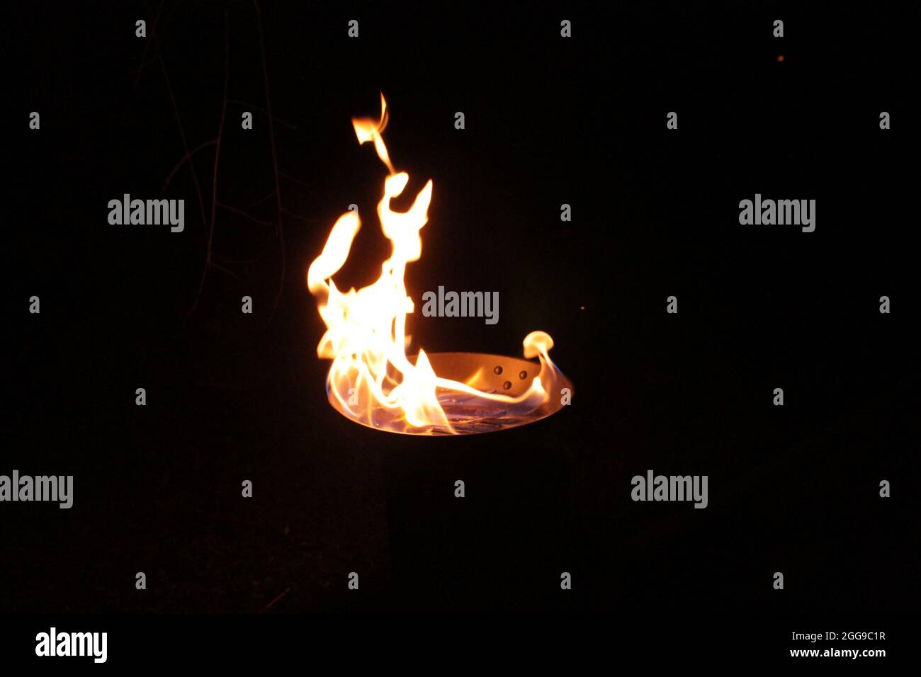 huge ethanol flame rising out of a skillet at night. Black background Stock Photo