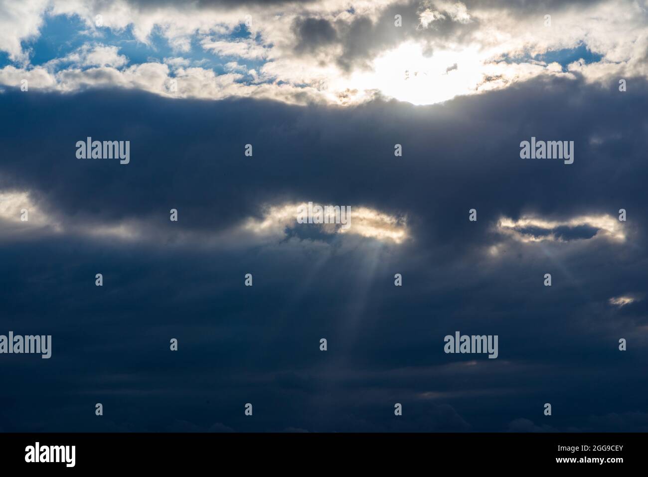 Rays of light shining throug dark clouds.Beautiful dramatic sky with sun rays.dramatic sky sun rays. Stock Photo