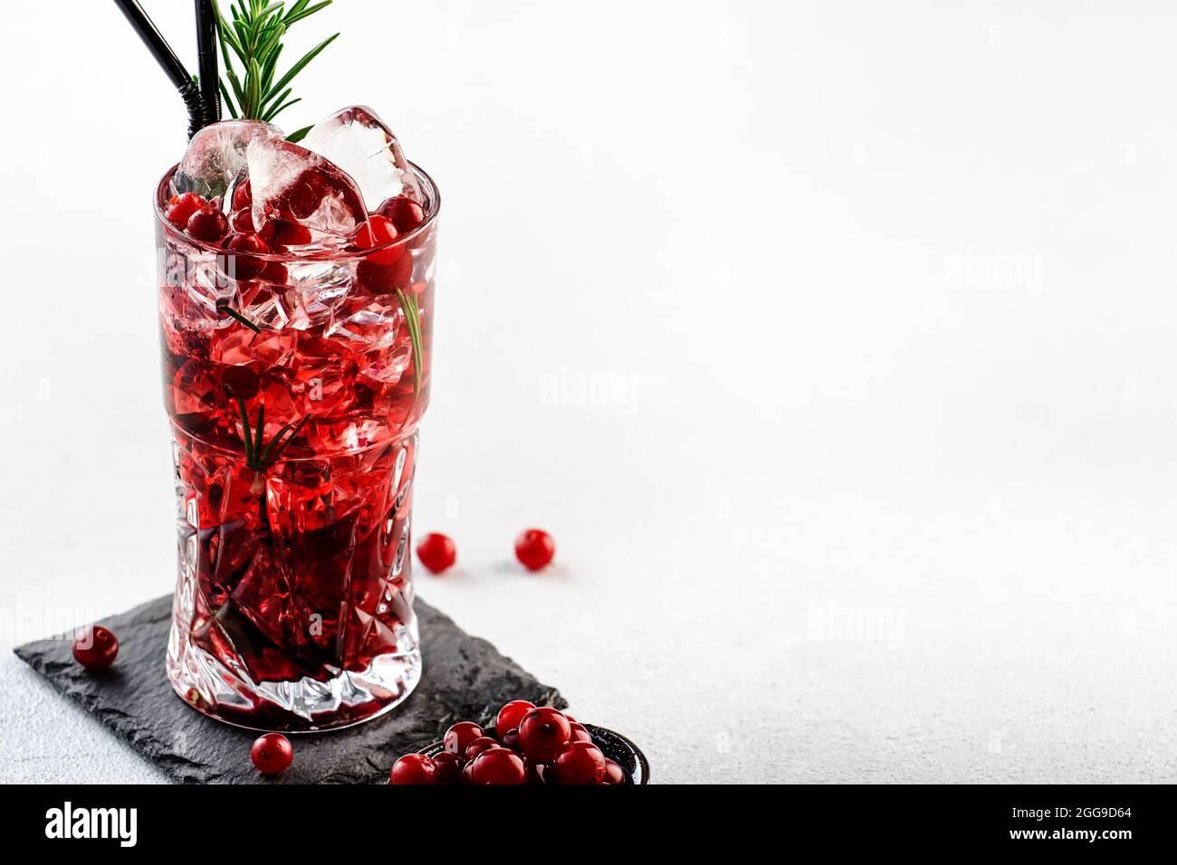 Cranberry cocktail with vodka, ice, juice, rosemary and red berries in
