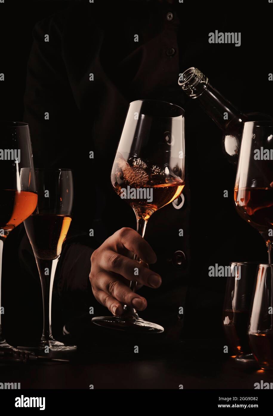 https://c8.alamy.com/comp/2GG9D82/sommelier-pouring-rose-wine-into-glass-at-wine-tasting-in-winery-bar-or-restaurant-black-toned-image-2GG9D82.jpg