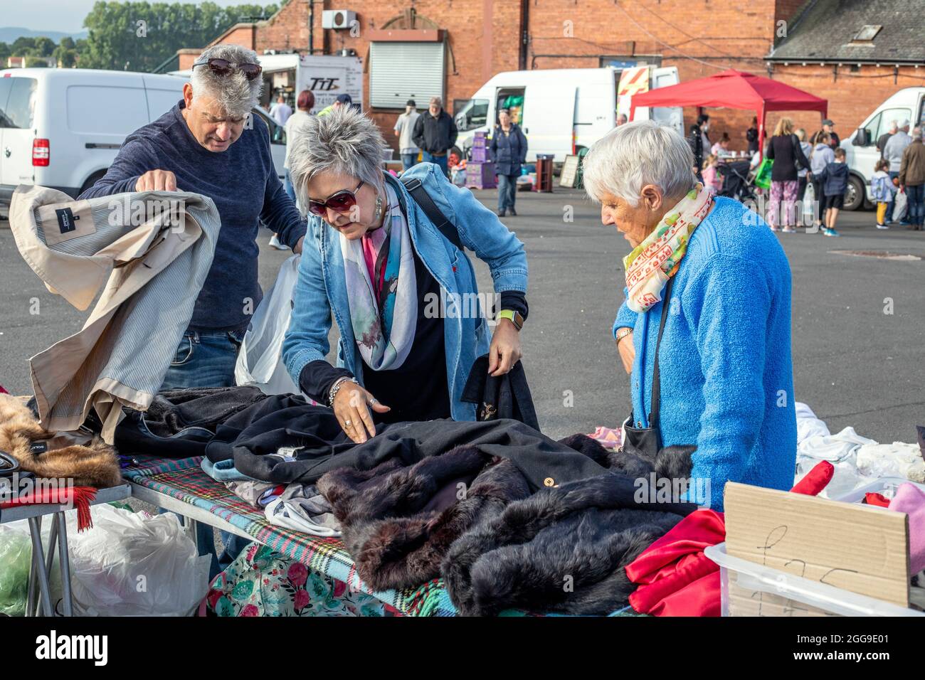 People looking or bargains at the clothes stall at the car boot sale